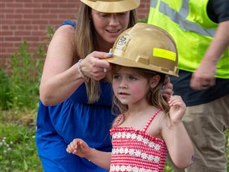Youngest Student putting on a hard hat